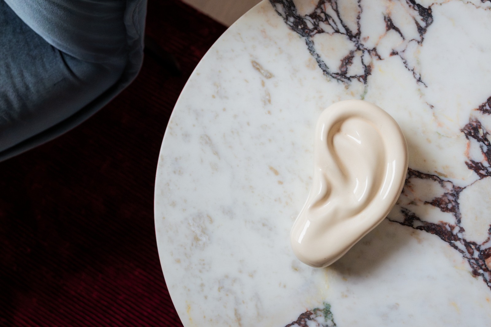 Sculptural ear on marble — a quiet symbol of hearing care